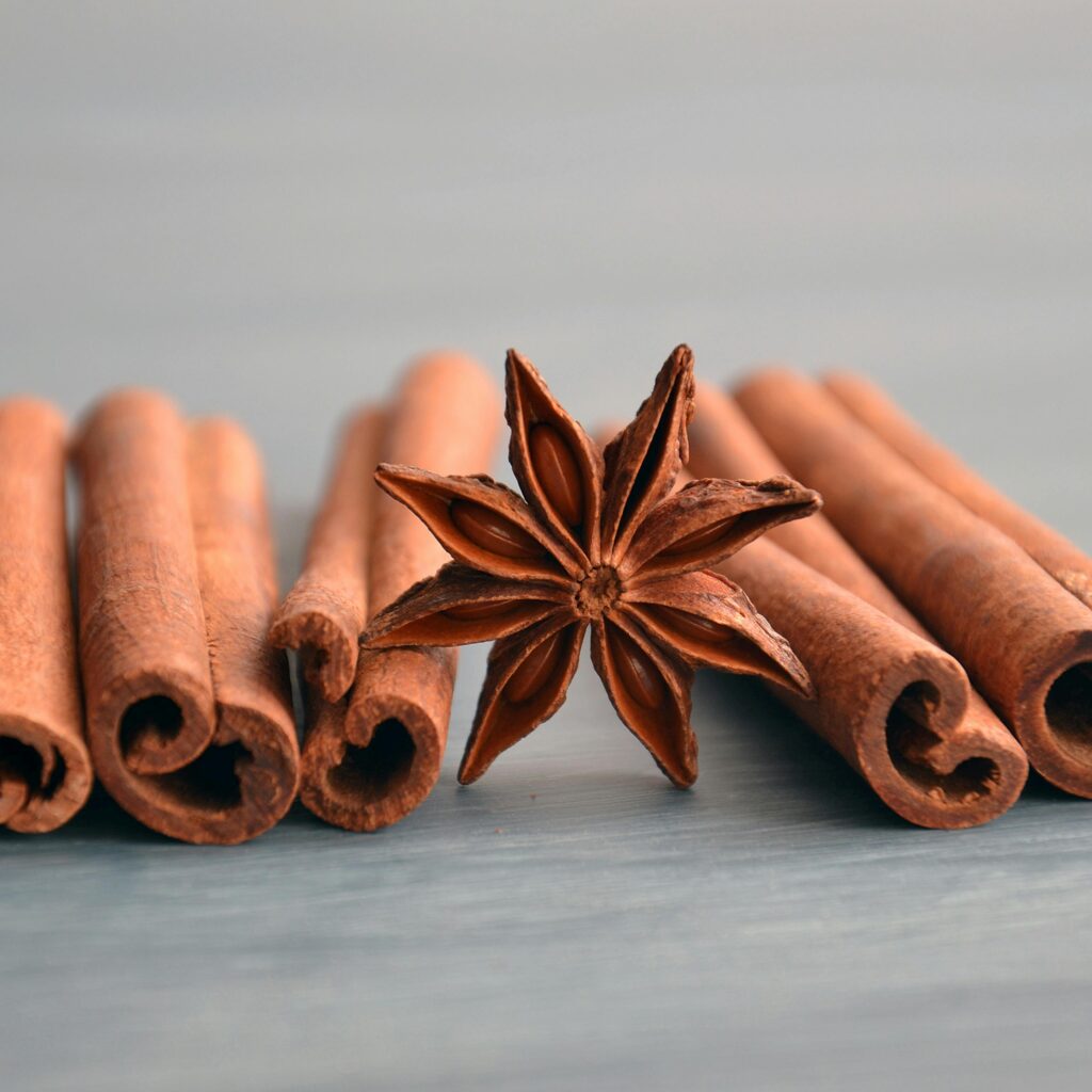 Cinnamon sticks and star anise on a wooden surface, perfect for culinary themes.