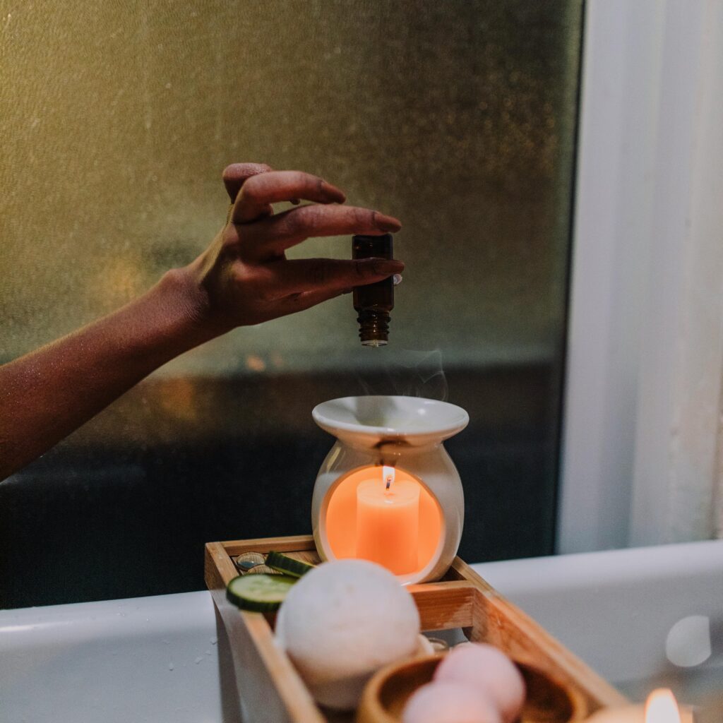 Serene spa setting with aromatherapy oil, candle burner, and bath accessories for relaxation.