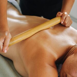 Close-up of a woman enjoying a soothing bamboo massage in a spa setting.